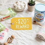 Baby care products including diapers, wipes, and lotion on a soft surface.