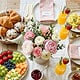 Mother's Day brunch table with flowers, fruit, and drinks for a family celebration.