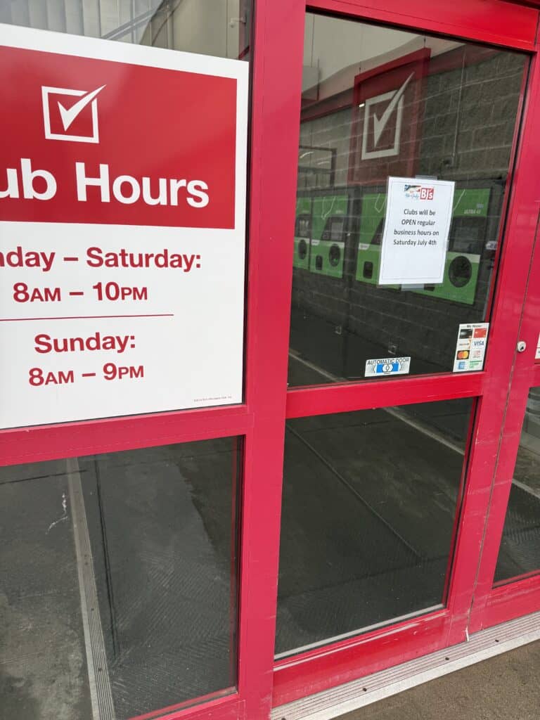 Store entrance with hours and COVID-19 safety notice.