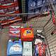 Shopping cart filled with laundry and cleaning supplies at wholesale store.