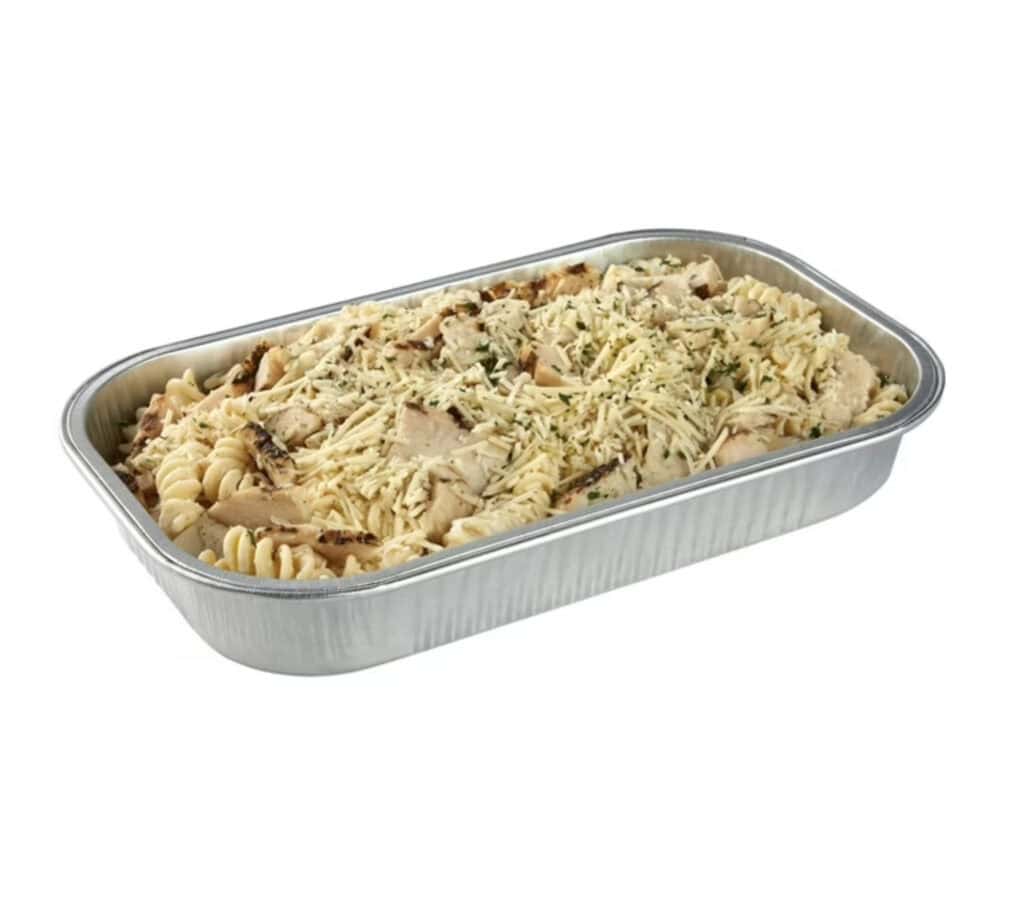 Chicken pasta casserole in a metal tray with herbs and cheese.